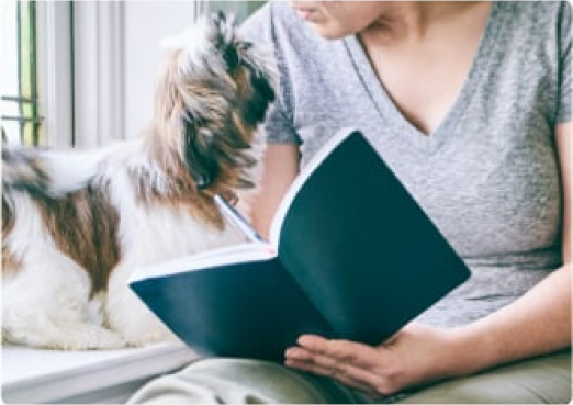Perro pequeño junto a su madre con un libro